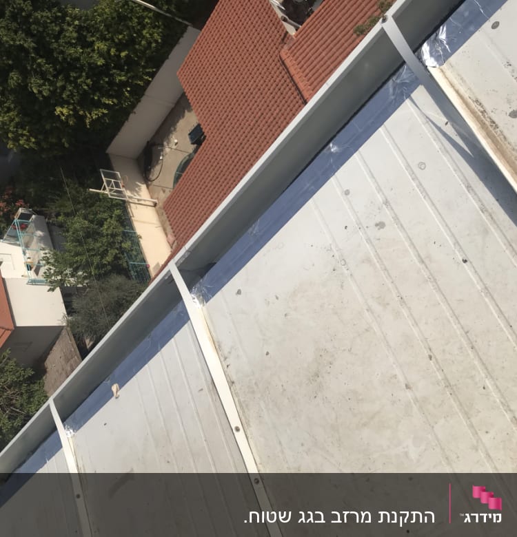 גג מתכת עם קורות לבנות ותפרים גלויים